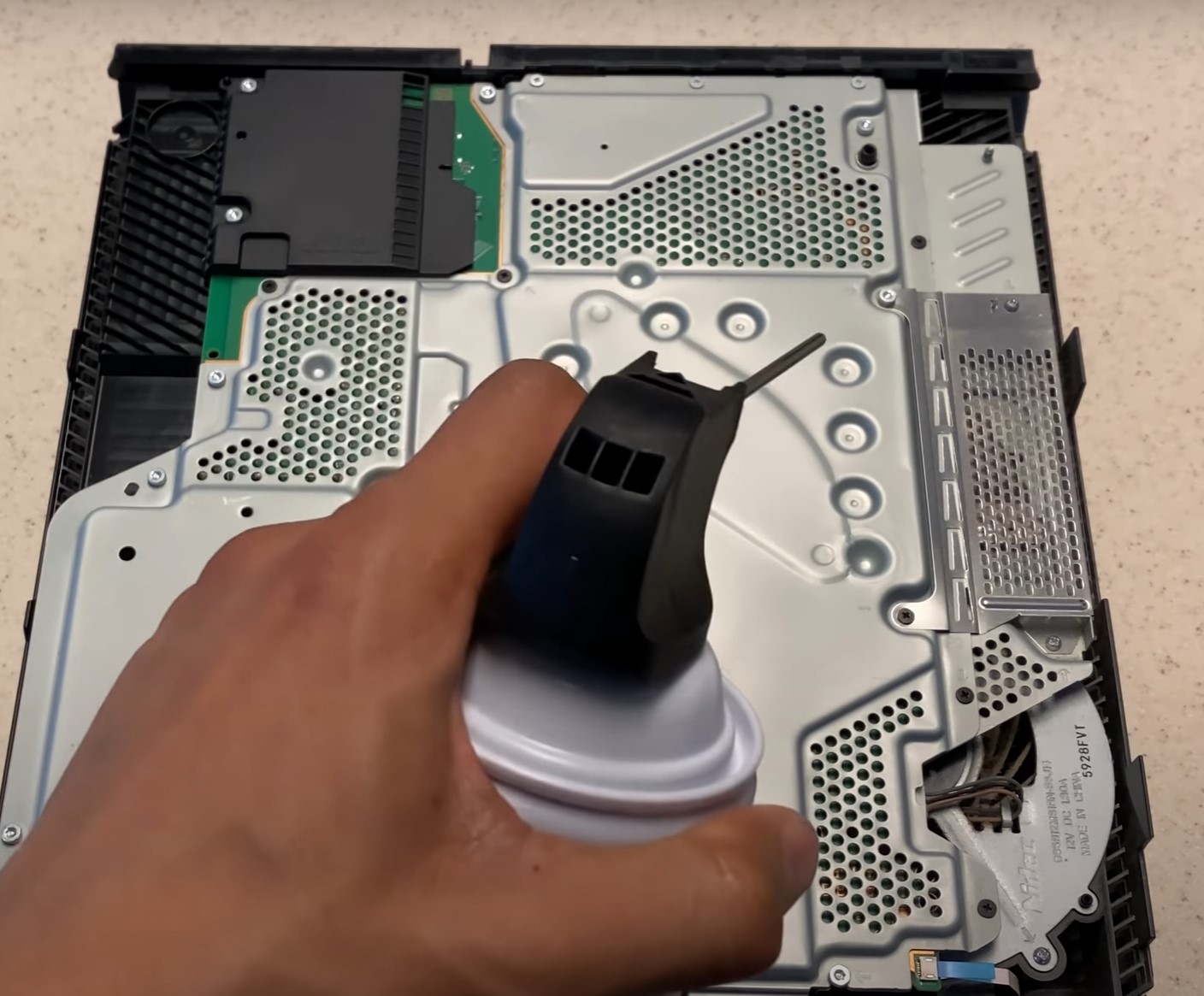 using compressed air can to clean the front side of playstation 4.