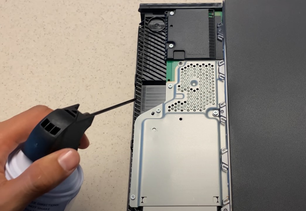 Using compressed air can to blow off dust.