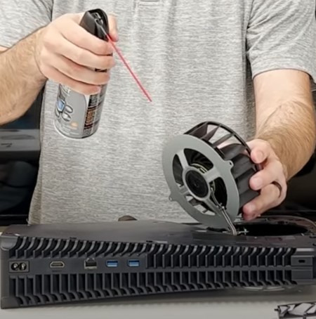 Removing dust from PS5 fans using compressed air can
