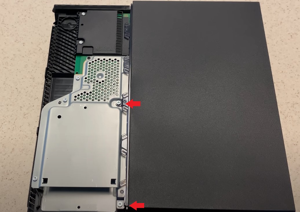 unscrewing screws to open the PS4 console.
